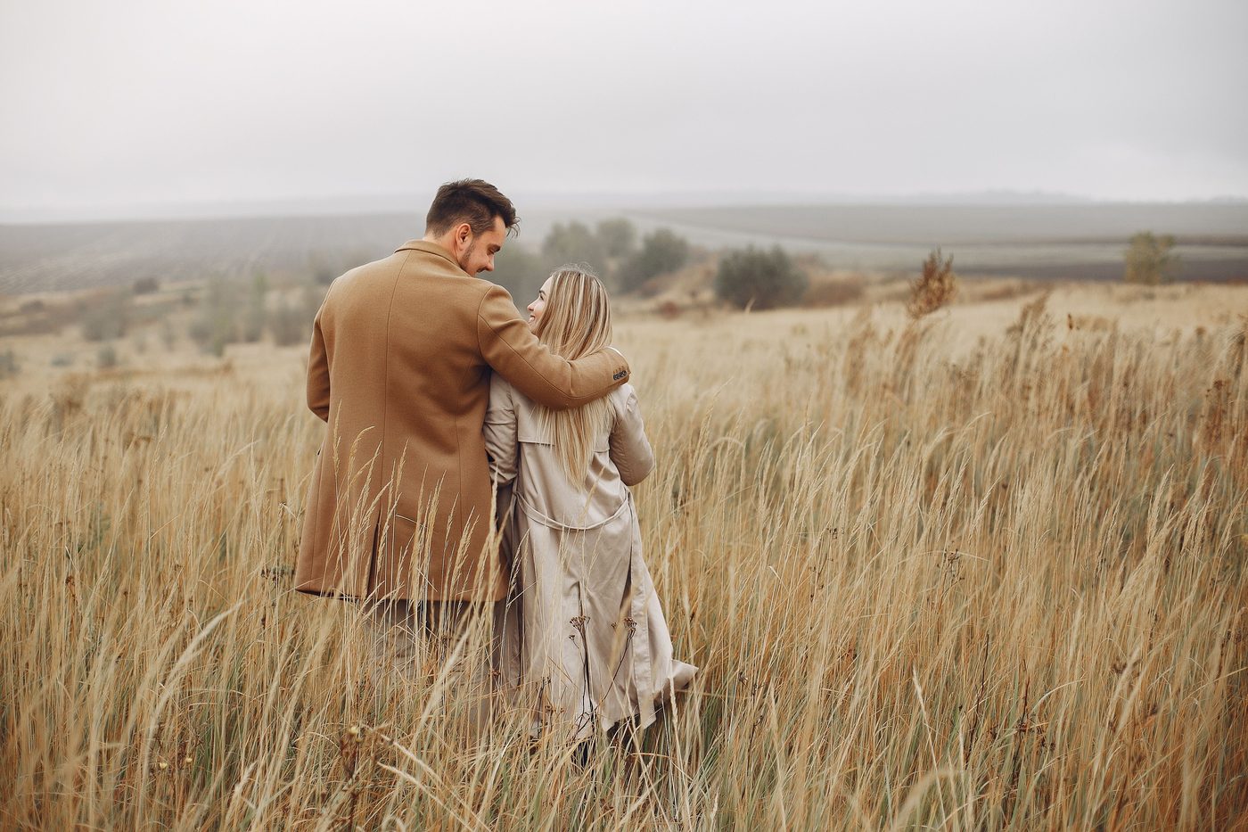 Mature couple walking through a golden countryside field