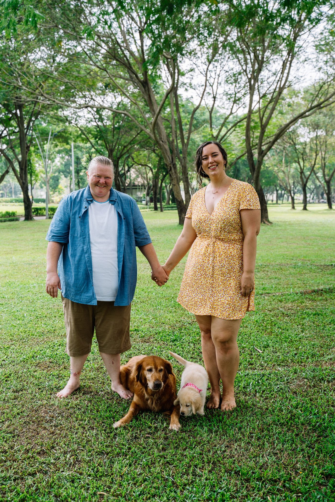 Mature couple smiling in a park with their dogs